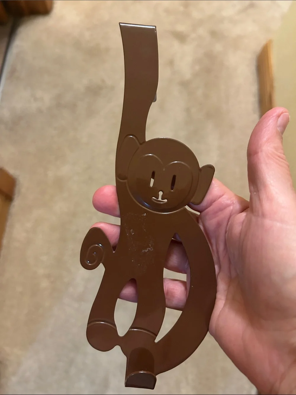 A set of 3 whimsical brown metal monkey over-the-door hooks